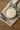 White cream in a bowl on a beige cloth with lavender and eucalyptus leaves on a wooden surface